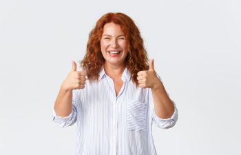 Happy broaldy smiling mature woman showing her thumbs up.